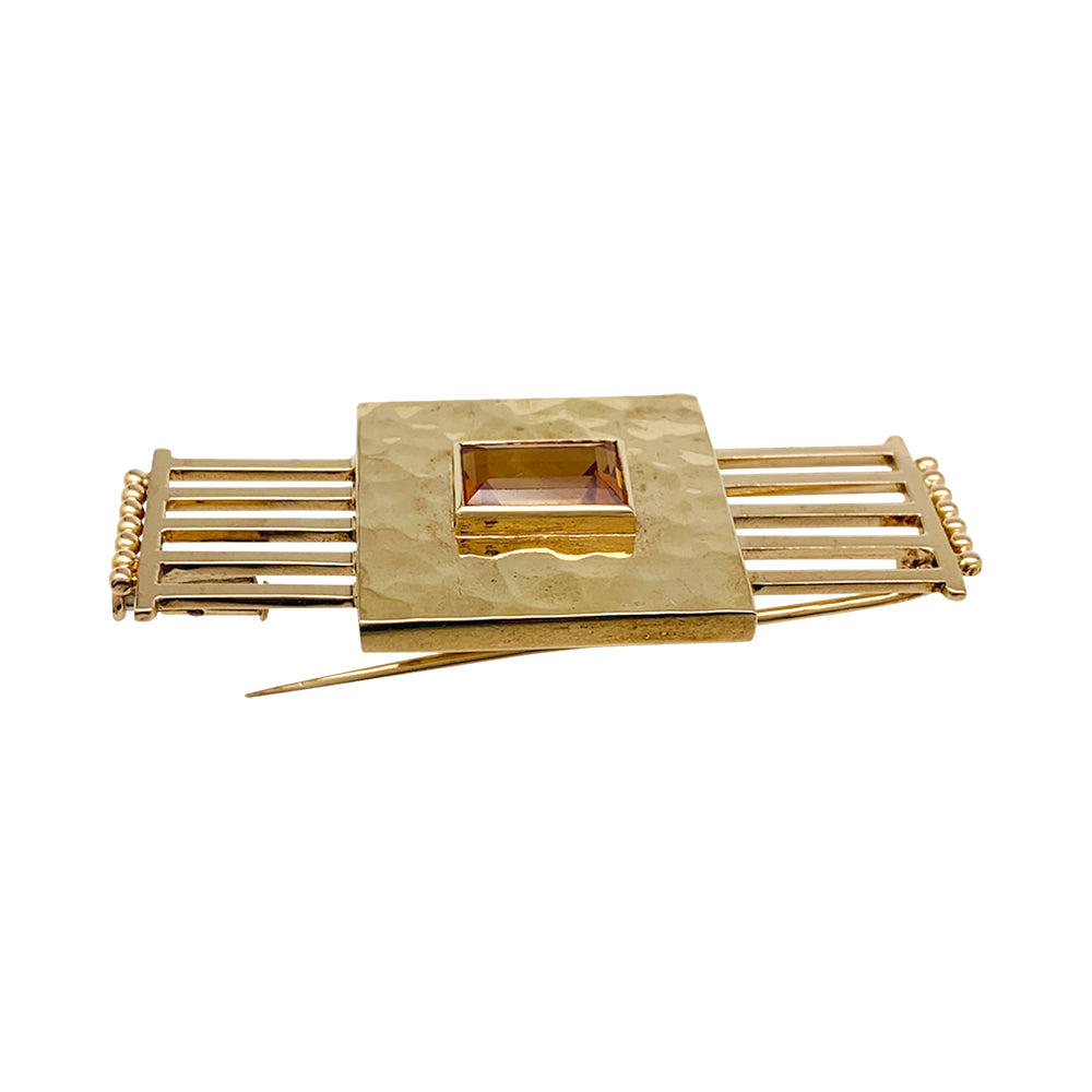 Une broche géométrique signée Jean Desprès en or jaune 750/000 martelé et lisse, centrée d’une citrine rectangulaire.  Poids brut: 17,2 grammes. 1