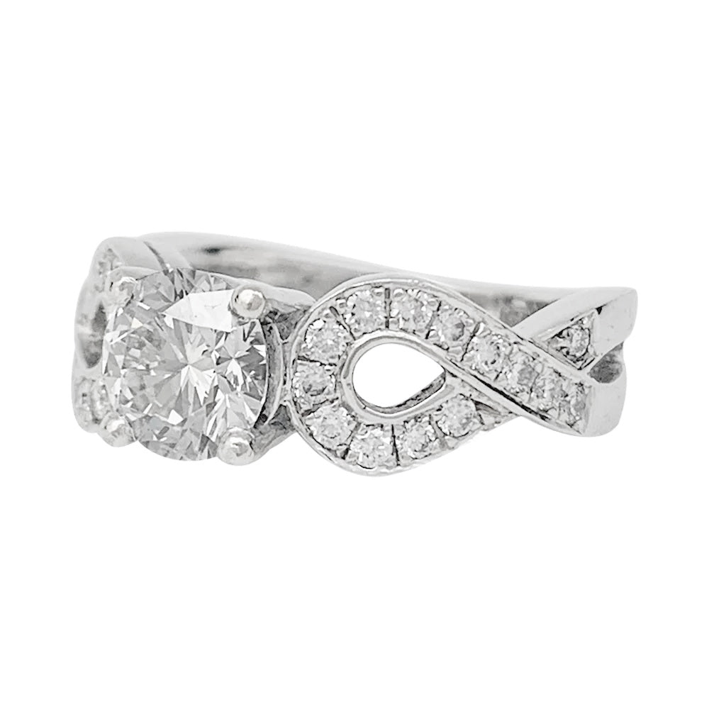 Solitaire en or blanc 750/000 centré d’un diamant taille brillant de 0,94 carat qualité E/VS1,certificat  GIA N°6147299507 (2012) épaulé de noeuds sertis de diamants.  Poids brut: 8,6 Grammes. 5